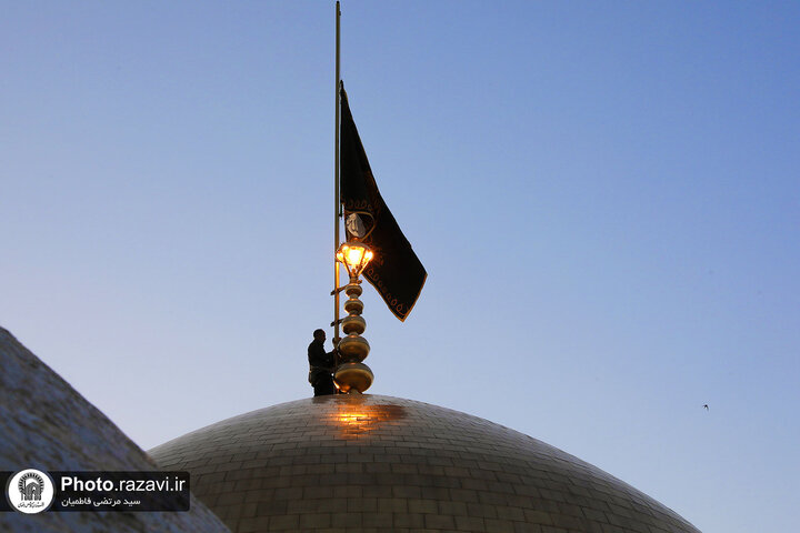 تقرير مصور/ رفع راية الحزن على قبة الإمام الرضا (ع) بمناسبة شهادة الإمام الصادق (ع)