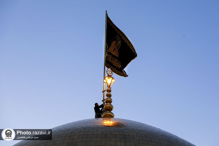 تقرير مصور/ رفع راية الحزن على قبة الإمام الرضا (ع) بمناسبة شهادة الإمام الصادق (ع)