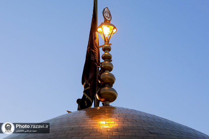 تقرير مصور/ رفع راية الحزن على قبة الإمام الرضا (ع) بمناسبة شهادة الإمام الصادق (ع)