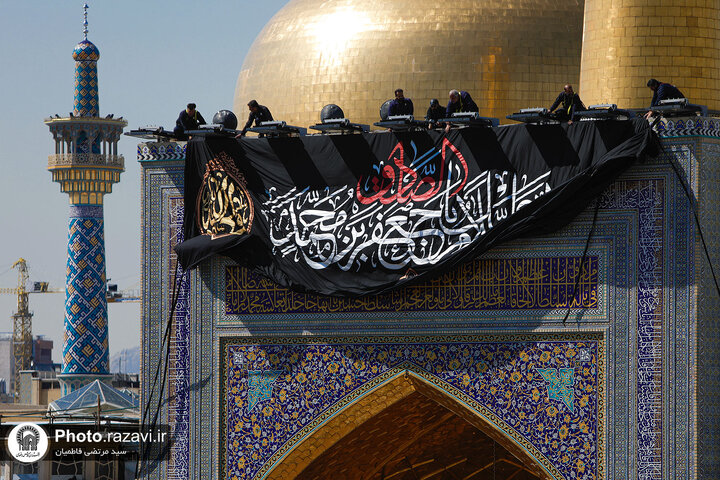 تقرير مصور/ رفع راية الحزن على قبة الإمام الرضا (ع) بمناسبة شهادة الإمام الصادق (ع)