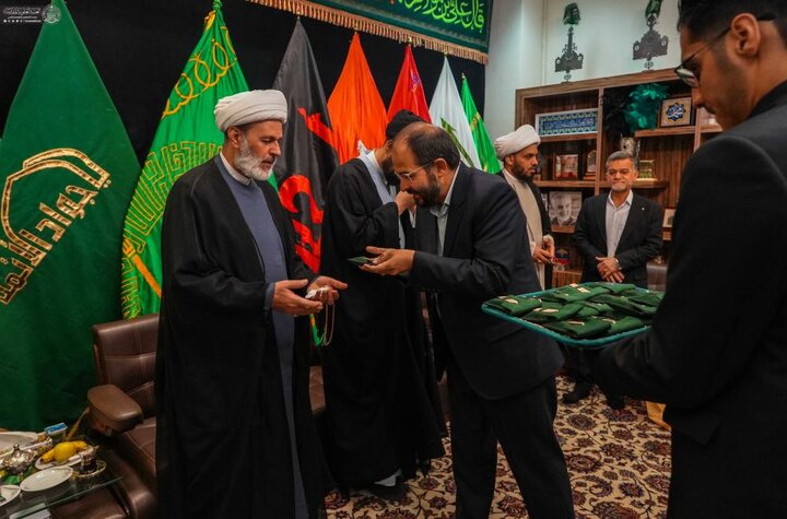 وفد العتبة العلويّة المقدّسة يقدّم راية المولى أمير المؤمنين (ع) إلى خدم العتبة الرضويّة المقدّسة