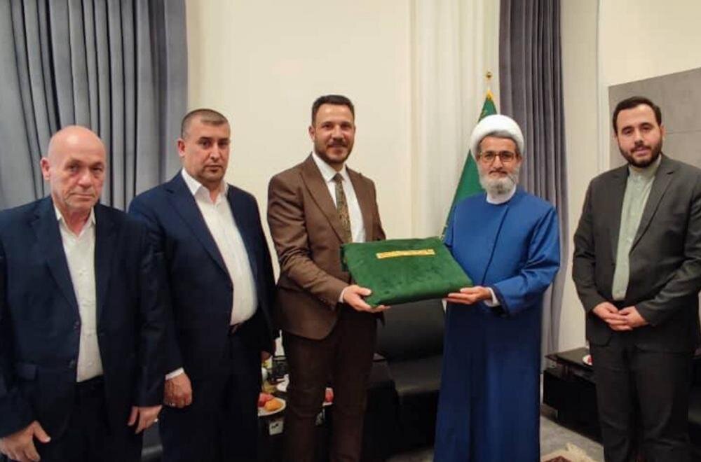 وفد العتبة العلويّة المقدّسة يسلّم راية الغدير الأغرّ إلى العتبة الرضوية المقدسة