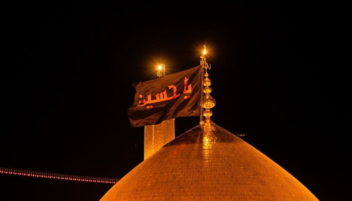 العتبة الحسينية تستبدل الراية السوداء بالحمراء على قبة مرقد الإمام الحسين (ع)
