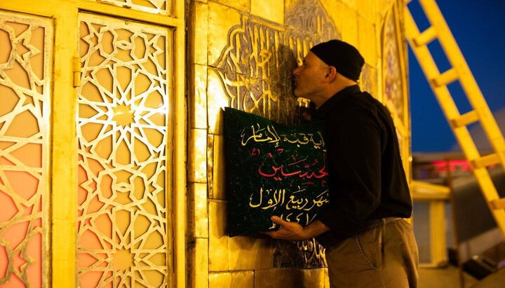 العتبة الحسينية تستبدل الراية السوداء بالحمراء على قبة مرقد الإمام الحسين (ع)