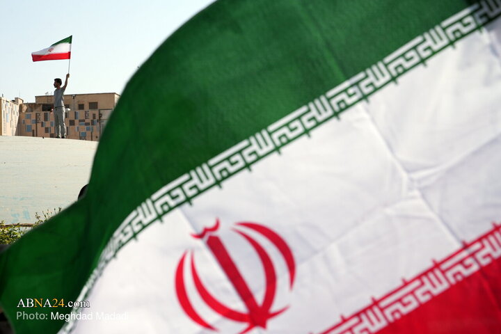 در حاشیه راهپیمایی «بشارت نصر» یکی از  شرکت‌کنندگان با پرچم جمهوری اسلامی ایران، در میدان انقلاب تهران ایستاده است.