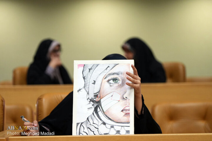 در حاشیه هشتمین اجلاس بین‌المللی همبستگی با کودکان و نوجوانان فلسطینی، یادواره شهید محمد الدره، کودکان شهید غزه و دفاع مقدس ۱۲ روزه یکی از شرکت کنندگان نقاشی ثبت شده از کودک فلسطینی را به دوربین نشان می‌دهد.