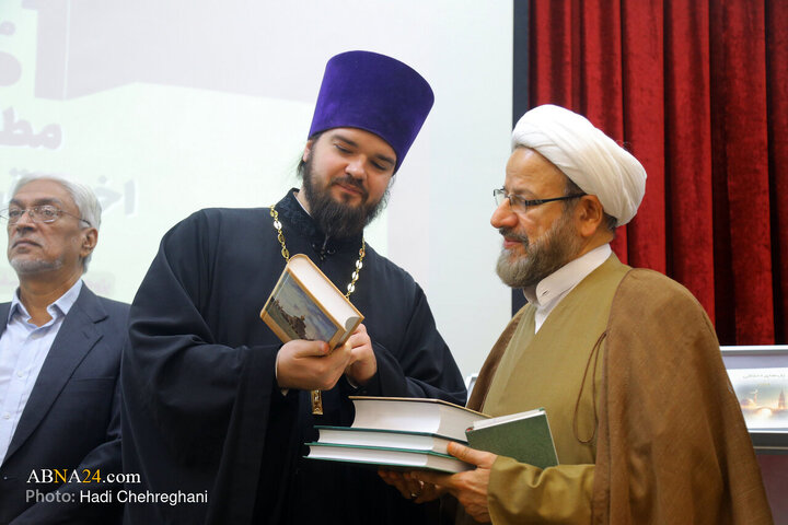 کشیش نیکیتا کوزنتسف، رئیس دانشگاه الهیات ارتدوکس کازان روسیه یکی از کتاب‌های رونمایی شده در همایش بین المللی مطالعات تطبیقی اخلاق در اسلام و مسیحیت را به حجت‌الاسلام والمسلمین احمد واعظی، رئیس دفتر تبلیغات اسلامی نشان می‌دهد.