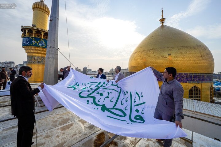 Informe fotográfico | Cúpula del Santuario de Amir al-Mu'minin, Imam Ali (la paz sea con él) adornada con una bandera: ‘La paz sea con la Excelencia Fátima al-Zahra (la paz sea con ella)’