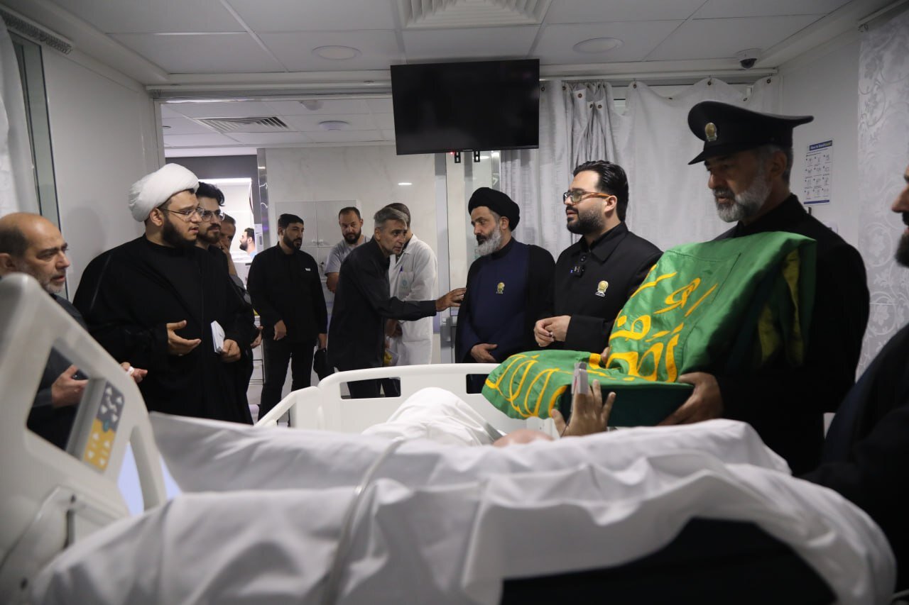 عکس خبری | تیمّن و تبرک جانبازان جنگ مقاومت لبنان به پرچم منور رضوی با حضور  جمعی از خادمان آستان قدس
