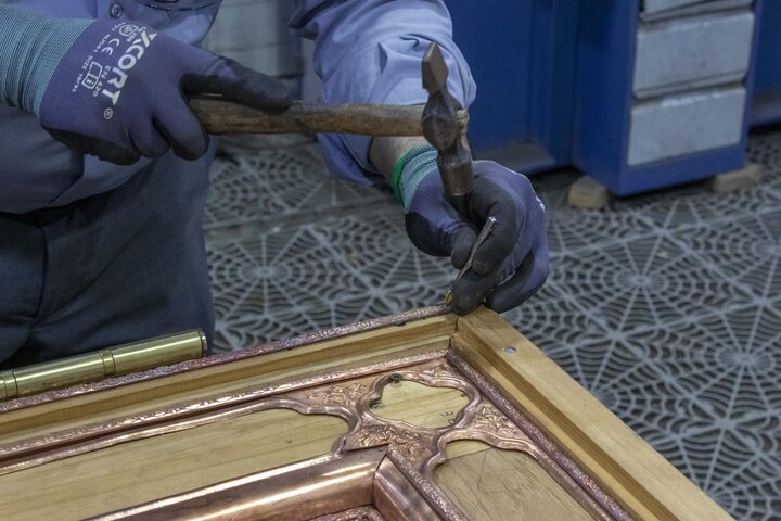 قرير مصور/  تركيب القطع المعدنية على الهيكل الخشبي لباب العباس (عليه السلام)