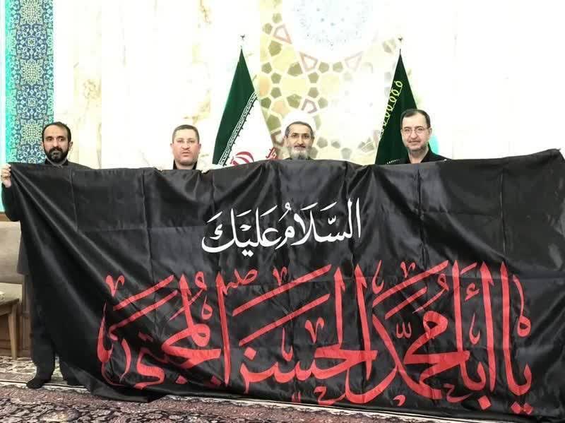 اهداء علم مُزَیّن باسم الامام الحسن المجتبی(ع) إلى الحرم الرضوي الطاهر