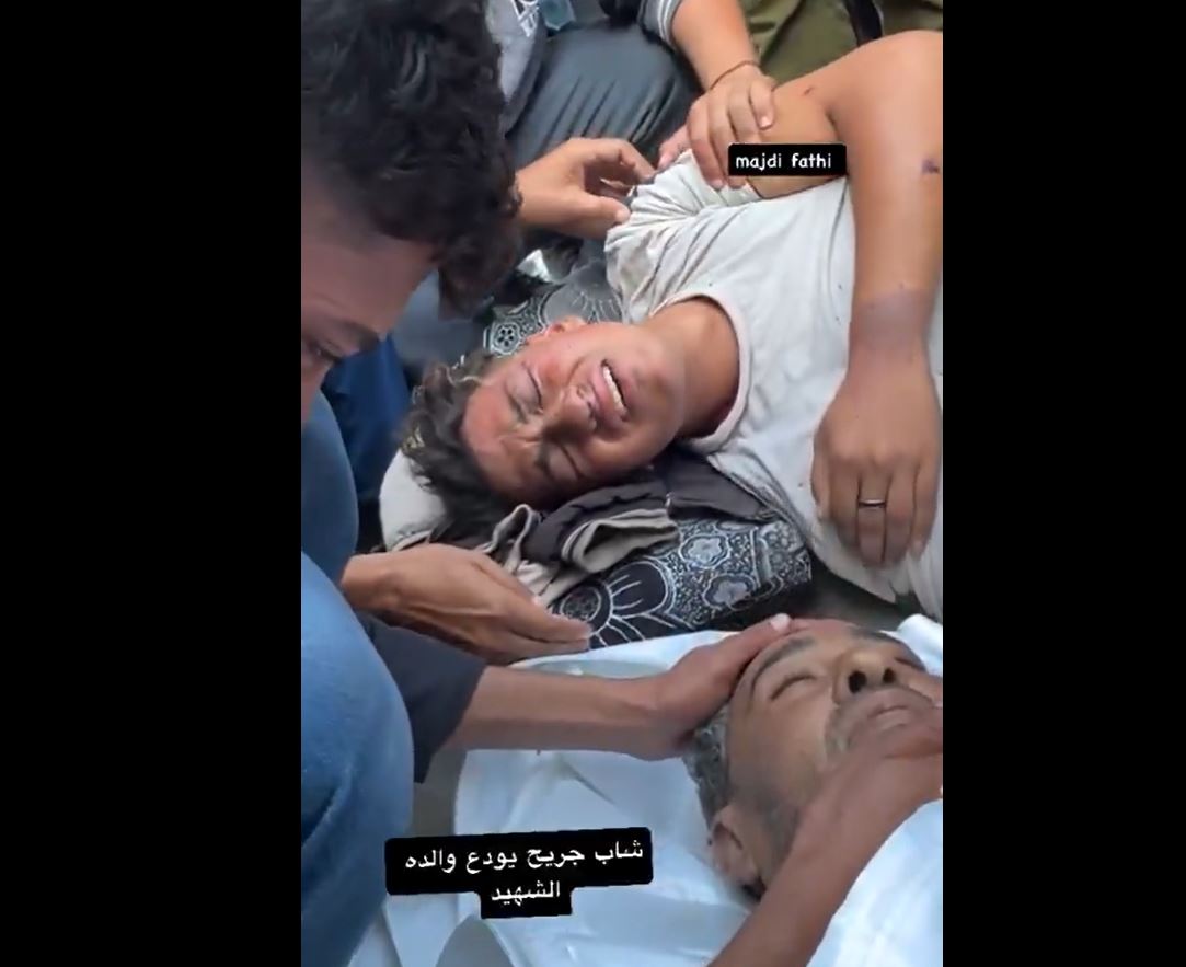Video: A wounded Palestinian bids farewell to his father, martyred in Israeli massacre in central Gaza