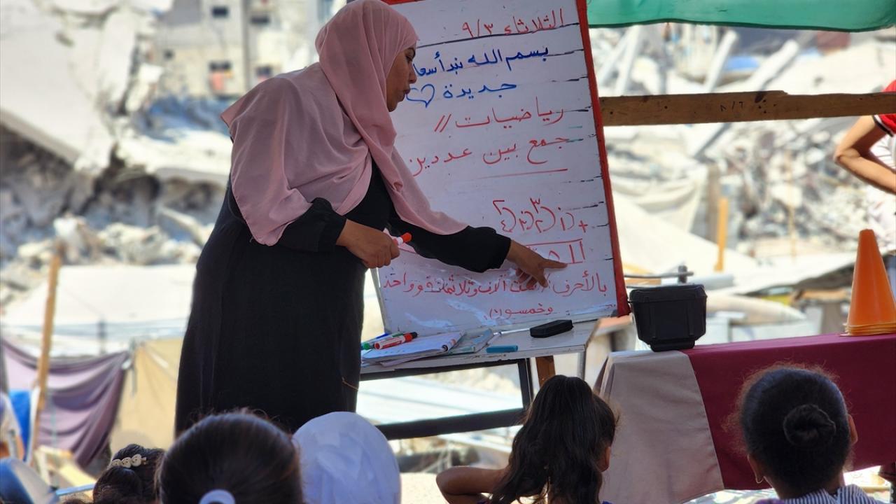 معلمة فلسطينية تواصل تدريس الاطفال بين الركام والدمار في غزة+(صور)