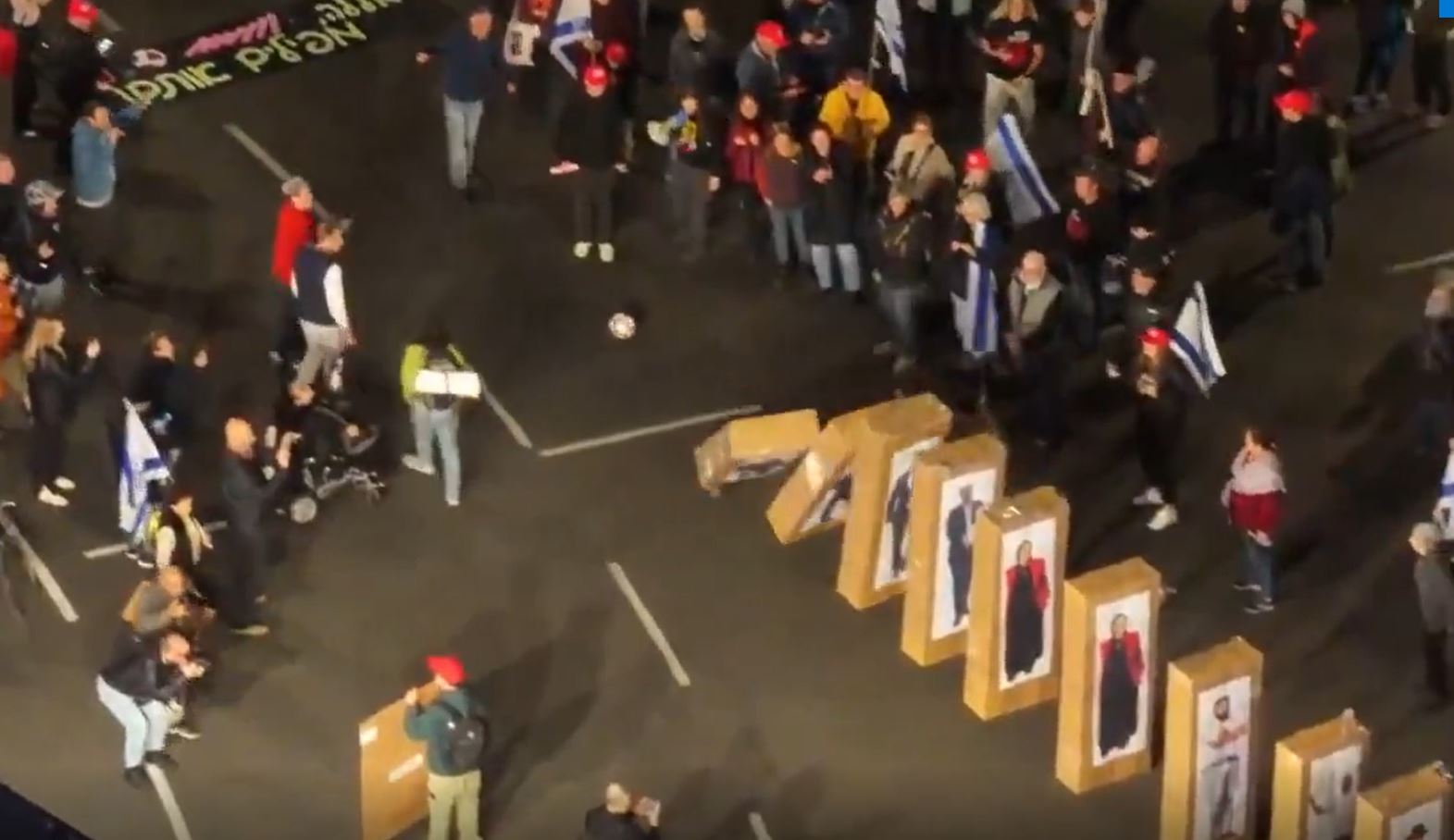 Video: Israelis topple pictures of government coalition leaders during a protest in Tel Aviv