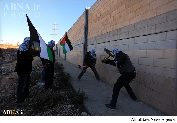بالصور / نشطاء فلسطينيون يهدمون جزء من جدار الفاصل قرب القدس المحتلة
