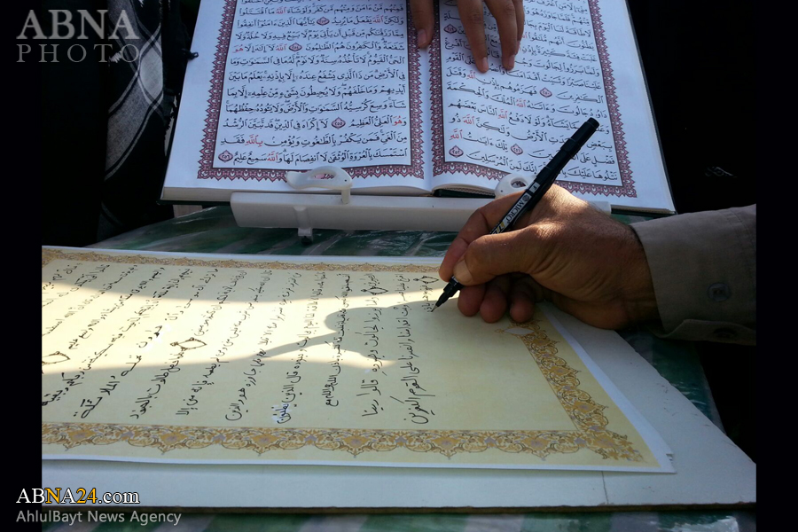 زوار أربعينية الامام الحسين (ع) يشاركون في كتابة القرآن الكريم + صور