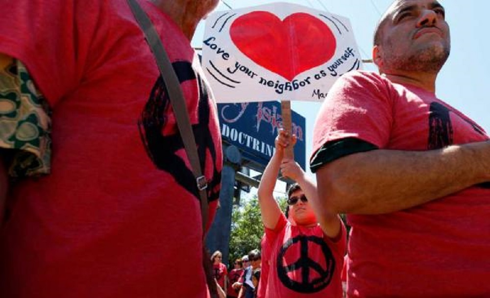 Peaceful protesters in Florida, USA share message of love beneath anti-Islam billboard