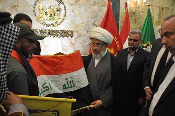 عائلة الشهيد الذي أعدمه داعش تهدي العلم لمتحف الامام الحسين (ع)+(صور)