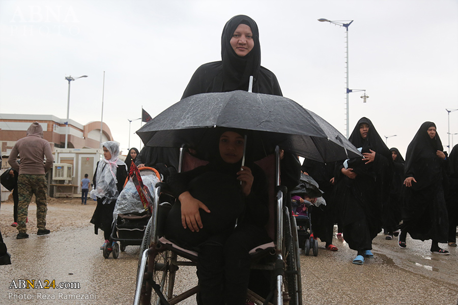 تقرير مصور/ زوار أربعينية الامام الحسين (ع) يواصلون السير اثناء هطول الامطار