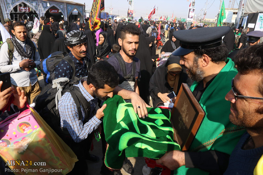 تقرير مصور/ زوار أربعينية الامام الحسين (ع) يتبركون براية السيدة المعصومة (ع)