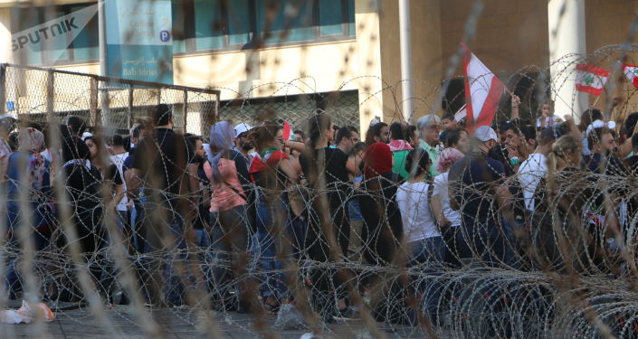 متظاهرون يحاولون تحطيم البوابة المؤدية إلى مقر مجلس النواب في وسط بيروت