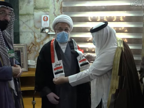 وفد من قبائل الموصل يقلدون ممثل المرجع السيستاني العلم العراقي +(صور)