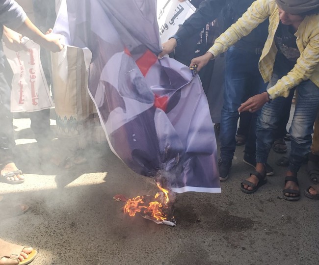 متظاهرون أمام السفارة الفرنسية في بغداد يحرقون صور ماكرون والعلم الفرنسي