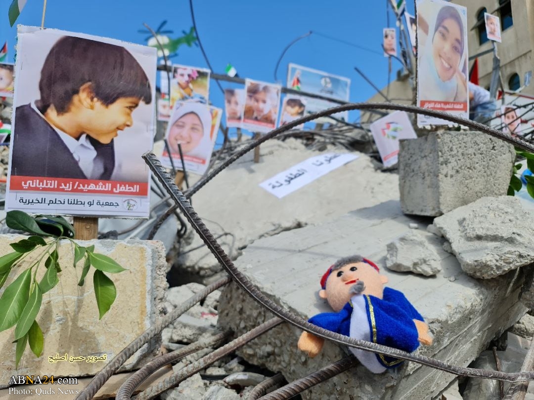 In Pictures: A Palestinian youth in Gaza held a gallery pictures on rubbles consist of 97 children killed in Israeli airstrikes 