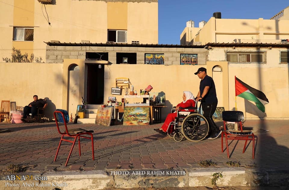 Photos: Palestinian couple drawing and displaying cultural-historical books in sidewalk of Rafah city, southern Gaza Strip