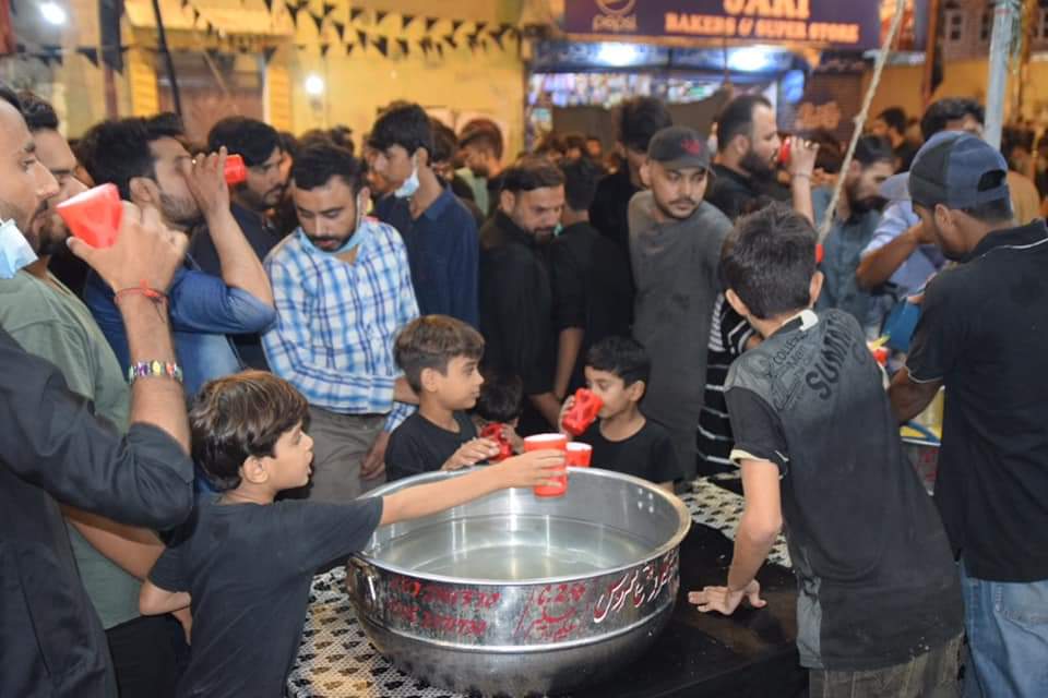 Photos: Distributing cold drinks in the name of Imam Hussain during Muharram mourning in Malir area of Karachi, Pakistan
